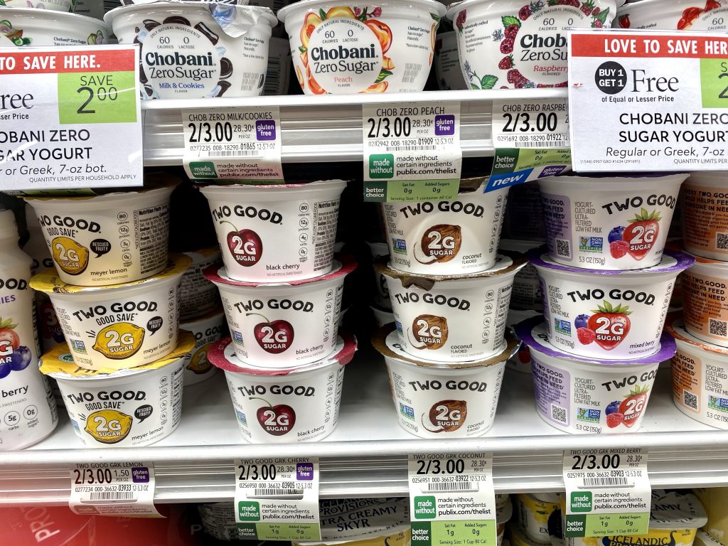 Containers of yogurt in the refrigerated case at the grocery store.