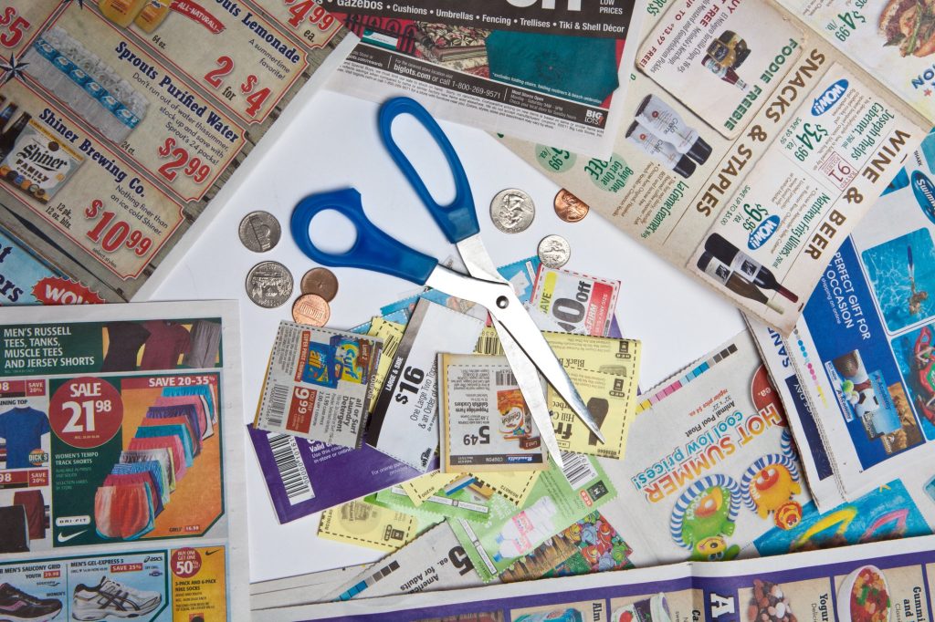 Scissors, newspapers and clipped coupons.