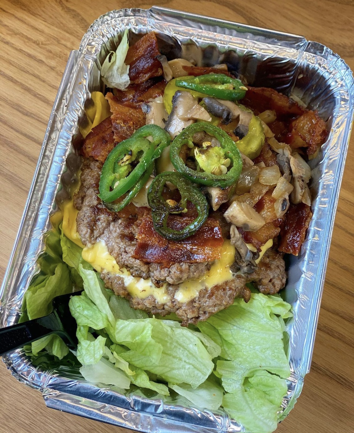 Five guys burger bowl with jalapenos onions, pickles and lettuce.