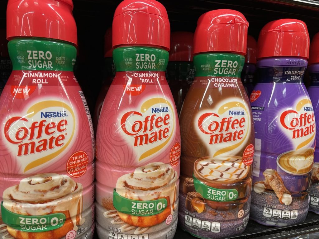 Bottles of zero sugar coffee creamer on grocery shelf.