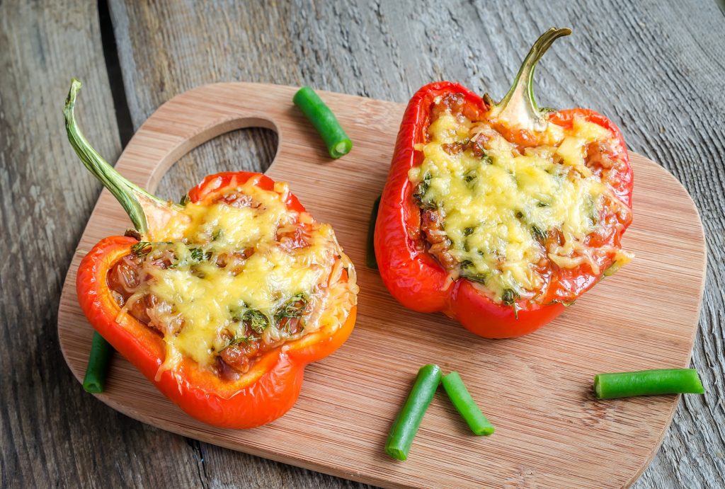 Bell peppers halves stuffed with meat and cheese and cooked.