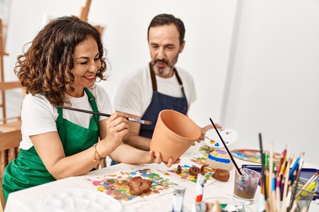 A man and woman at a painting glass together.