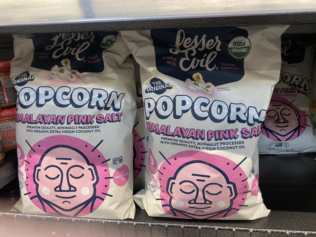 Bags of lesser evil popcorn on the grocery shelf.
