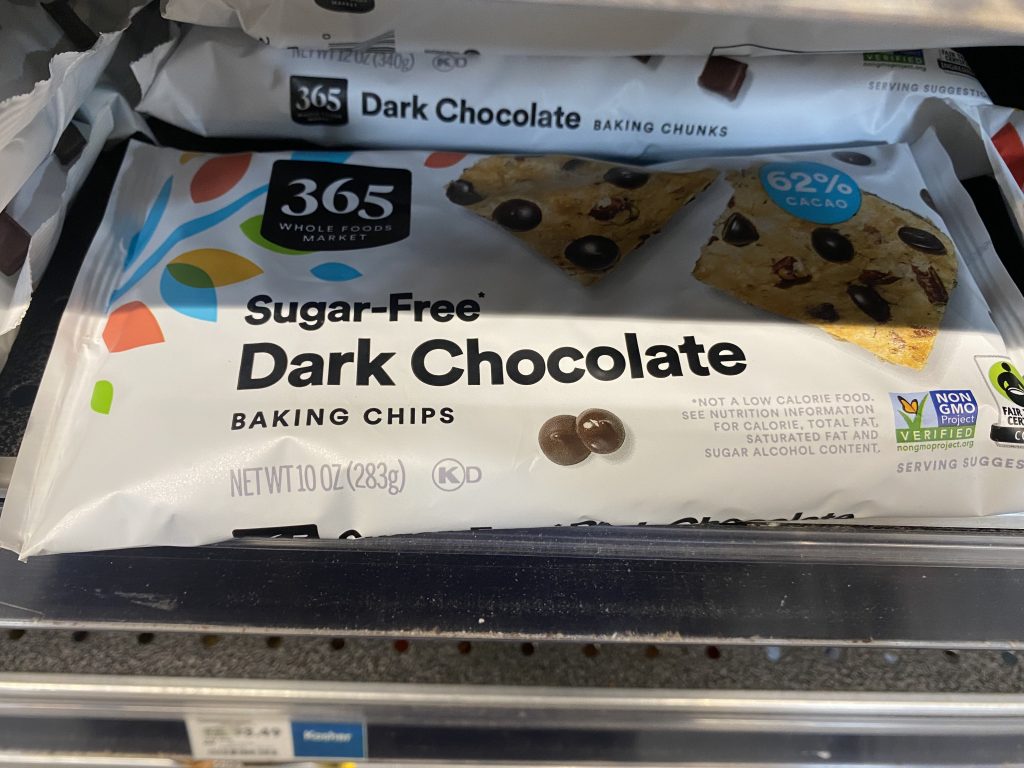 Bags of sugar free dark chocolate chips on the grocery shelf.