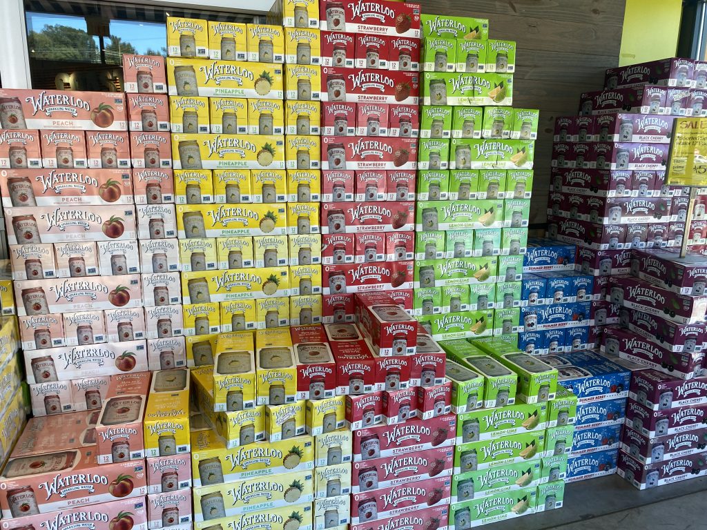 A large selection of boxes of canned sparkling water at the entrance of whole foods market.