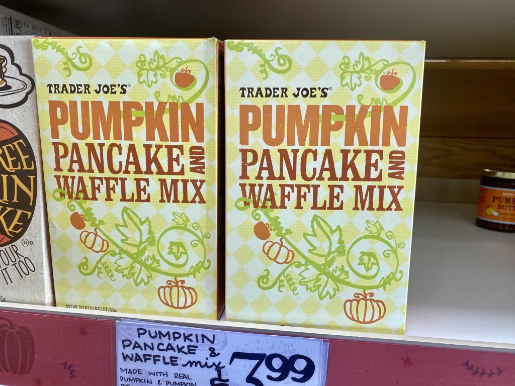 Boxes of pumpkin pancake mix on shelf at grocery.