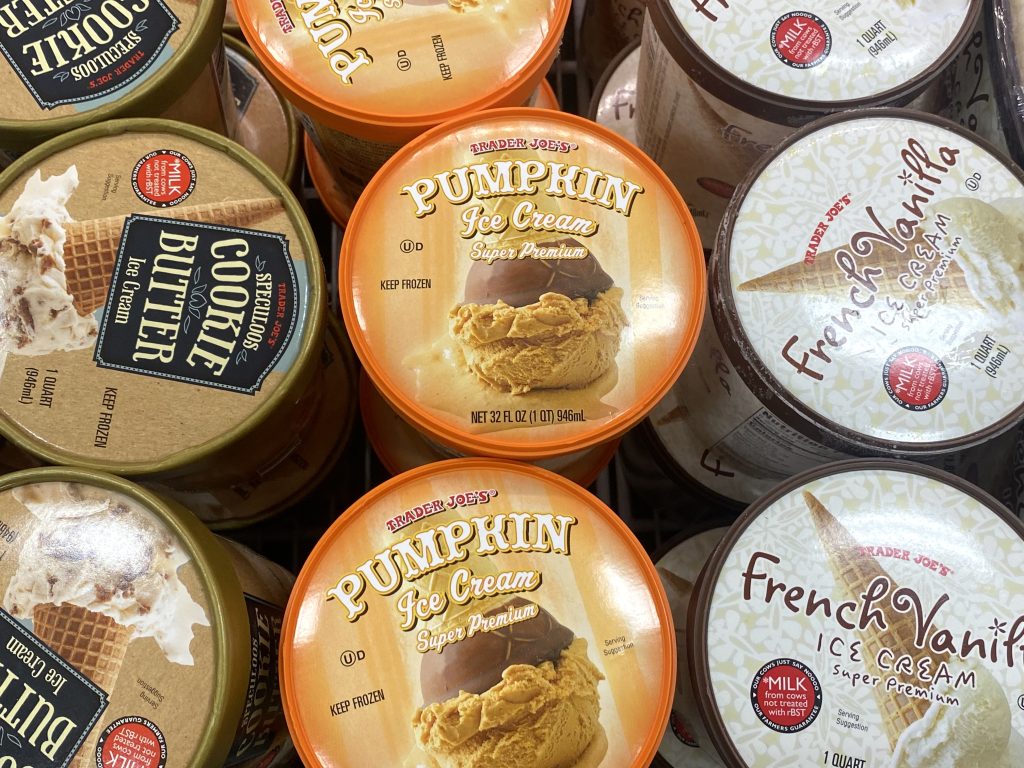 Containers of pumpkin ice cream in the freezer at grocery.