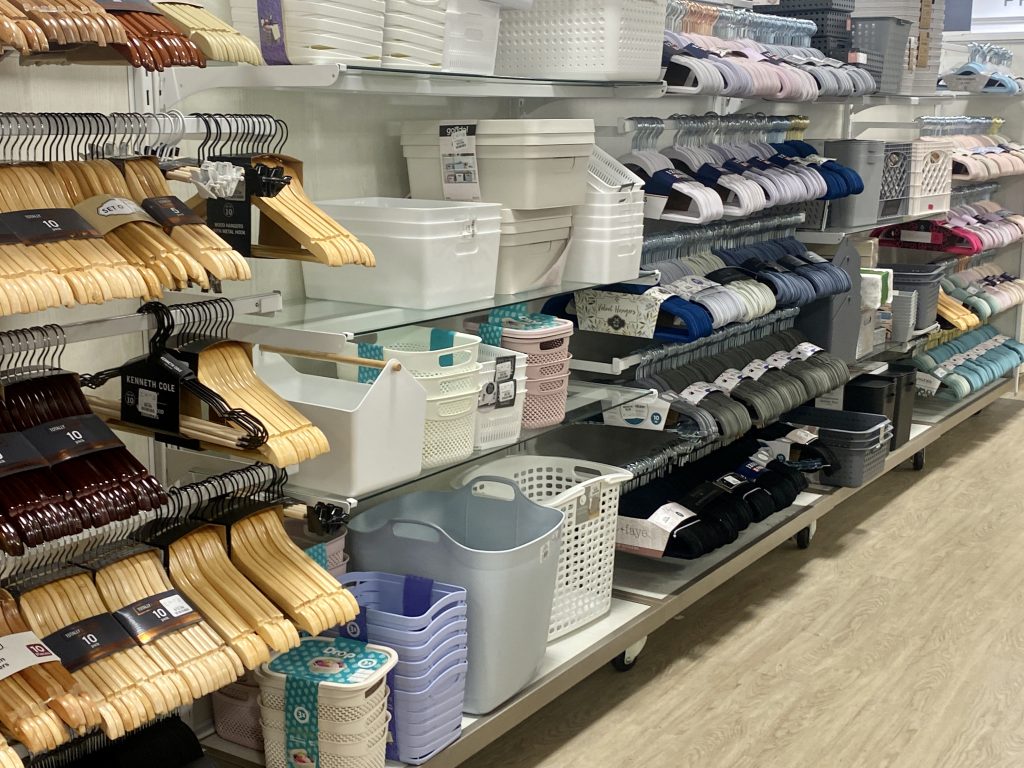 A store isle filled with hangers and organizational bins for sale.