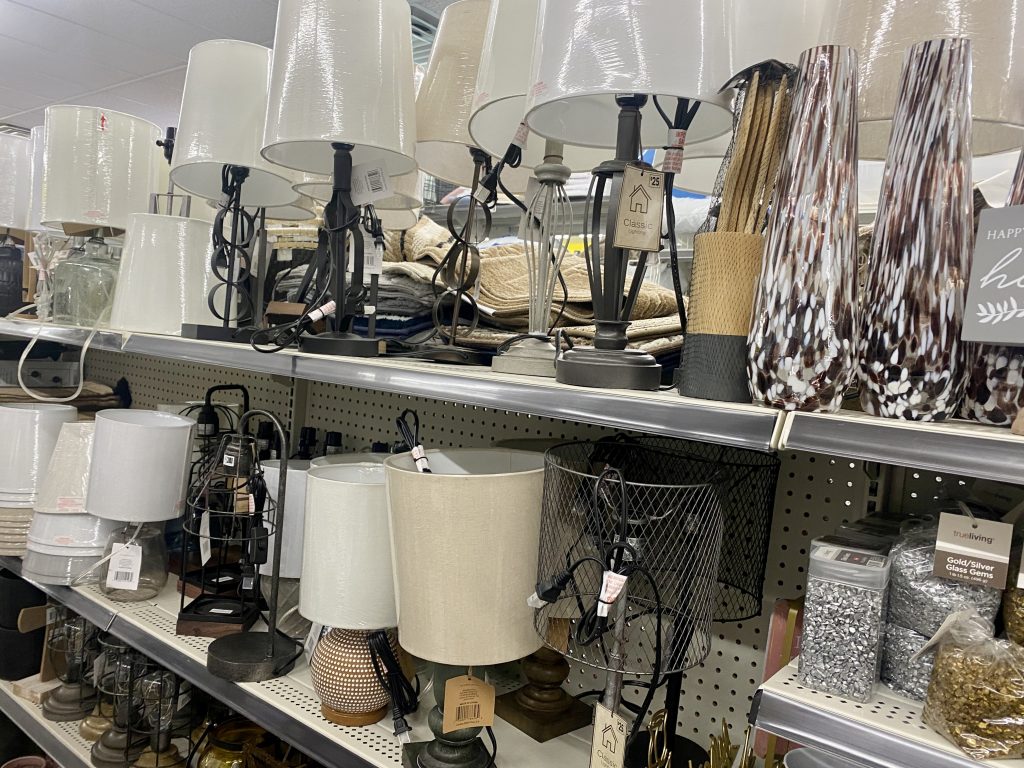 A variety of table lamps on a store shelf.
