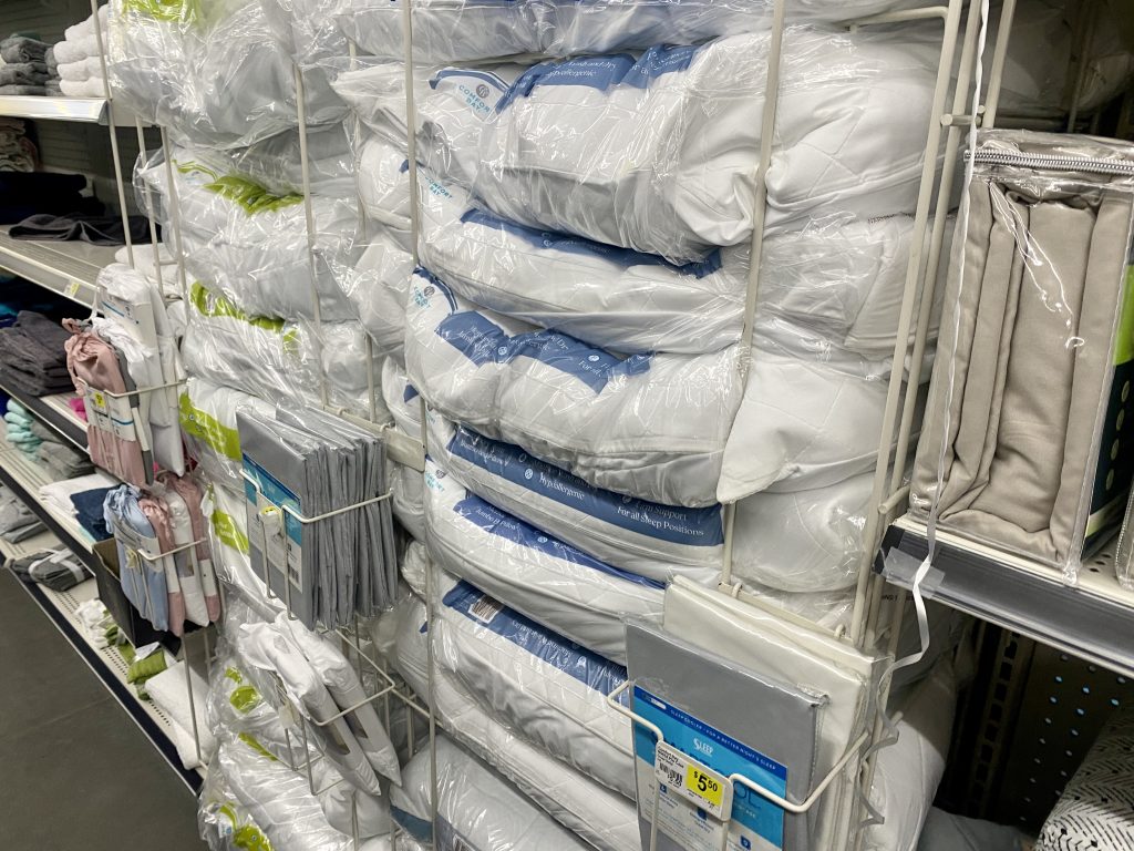 Bedding and pillows on store shelf.