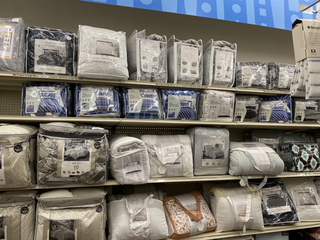 Comforters and other bedding on store shelf.