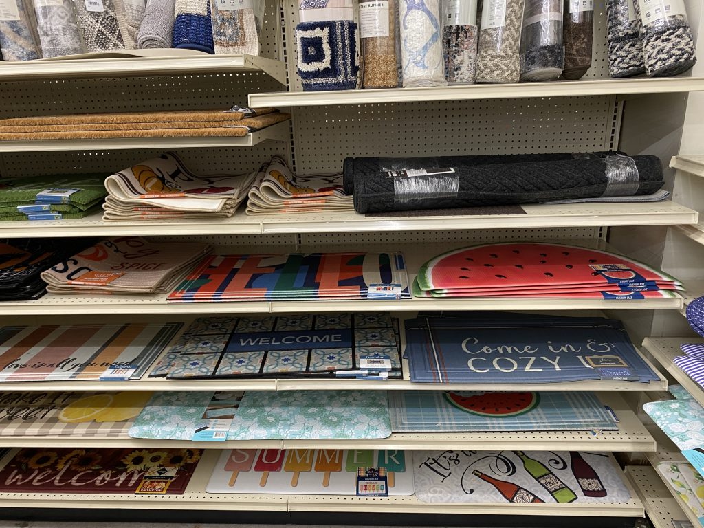 Doormats for sale on store shelves.