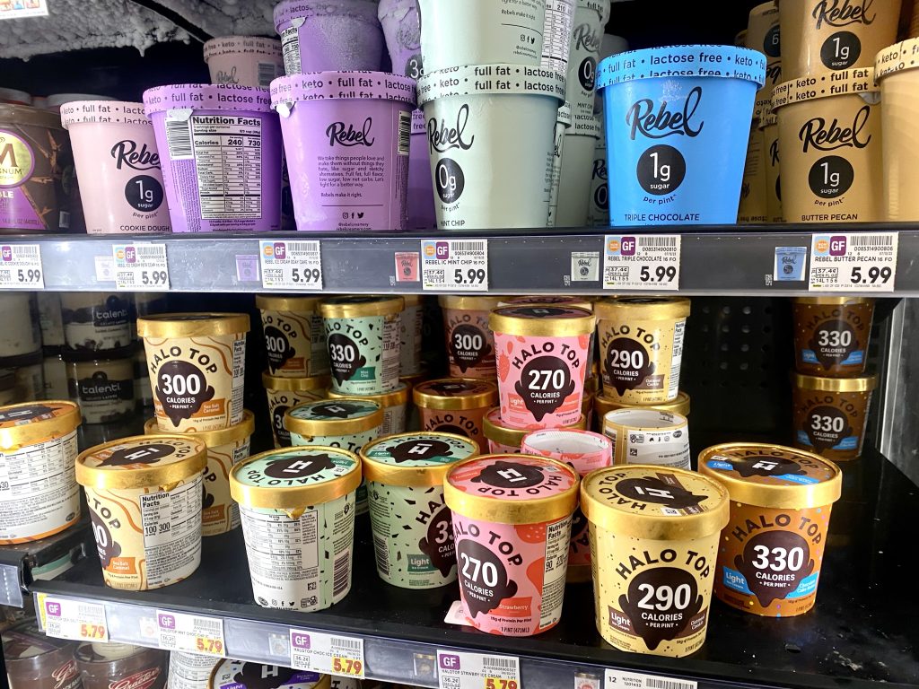 Pints of ice cream in freezer at grocery.