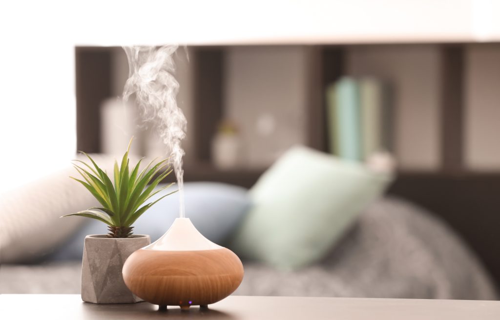 A diffuser diffusing essential oils in a cozy home.