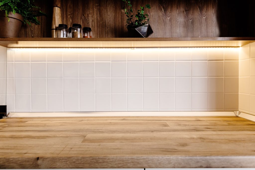 A photo showing a countertop and lighting under the cabinet above it.