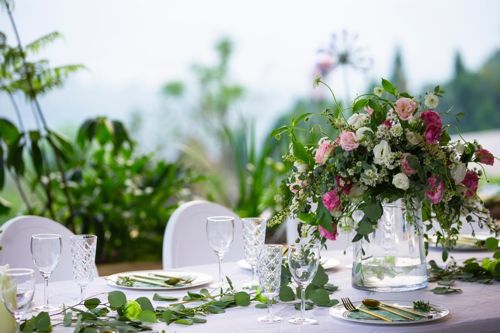 A large elegant centerpiece with colorful flowers at an outdoor party.
