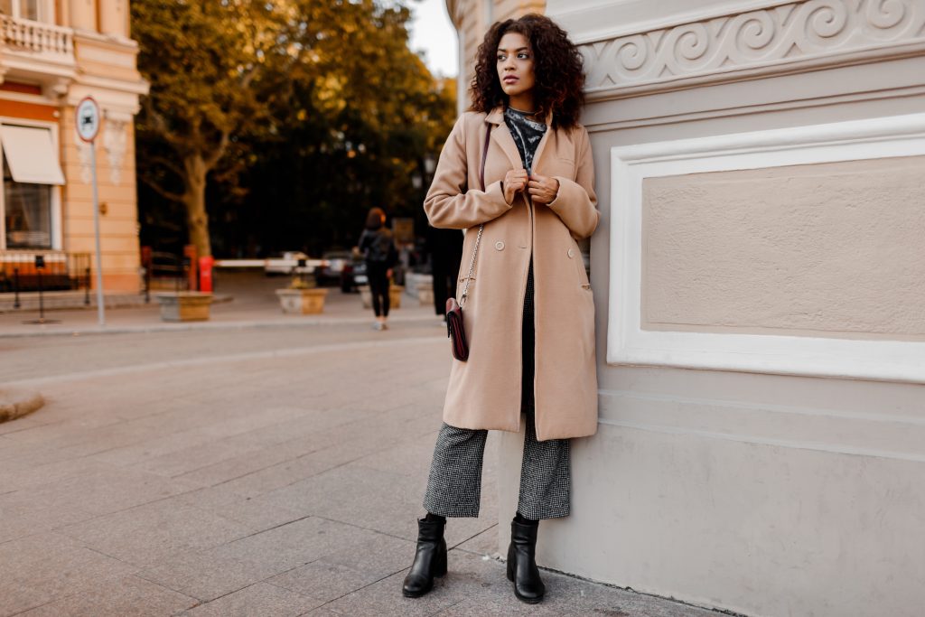 A woman wearing a tan wool long coat.