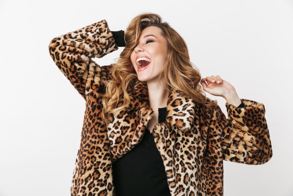 Smiling woman wearing a leopard coat.