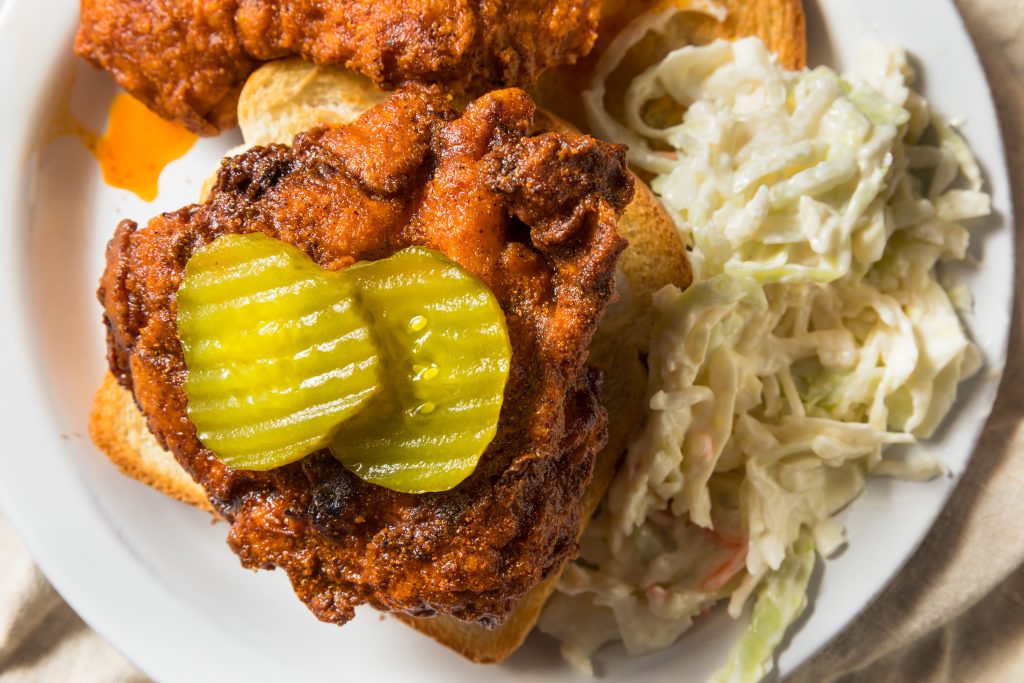 Nashville Hot Chicken on bread, topped with pickles. Coleslaw on the side.