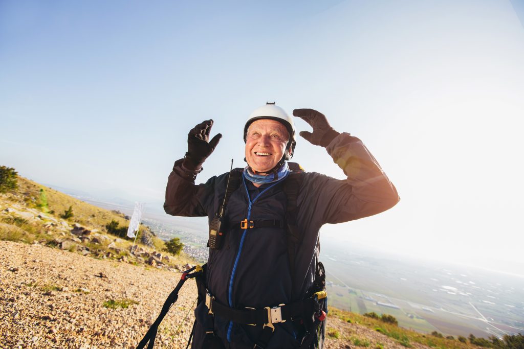 An older man on wearing gear preparing to skydive.