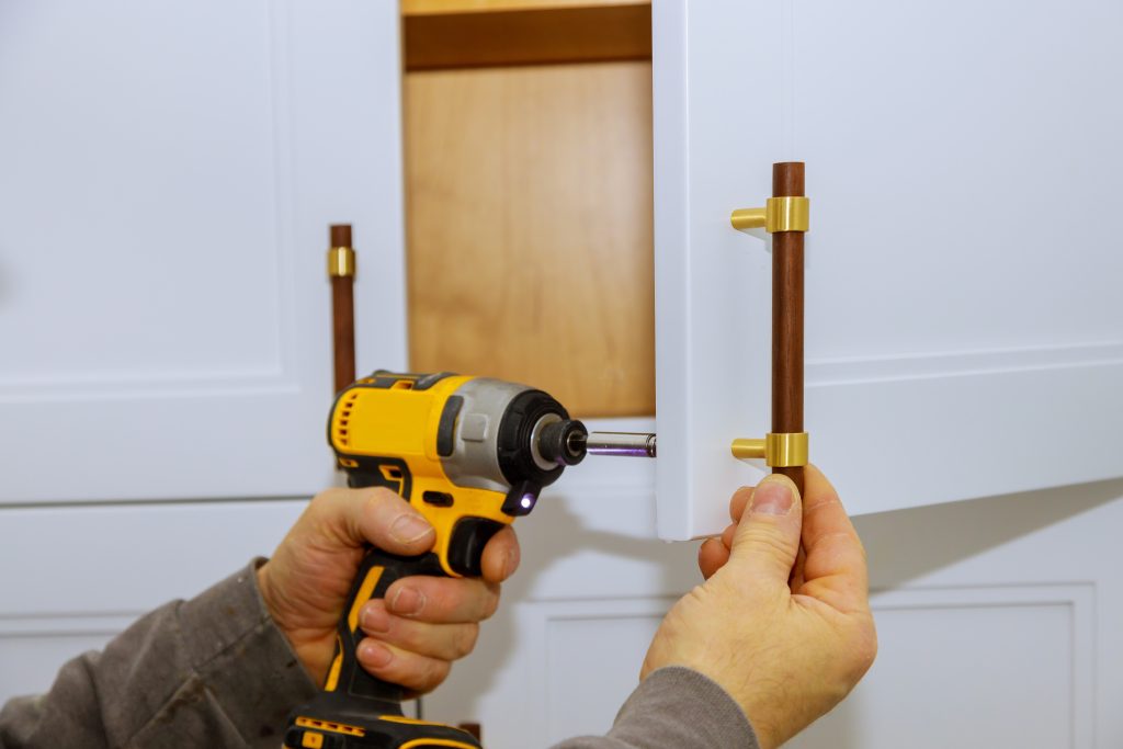 holding screwdriver and kitchen cabinet pull.