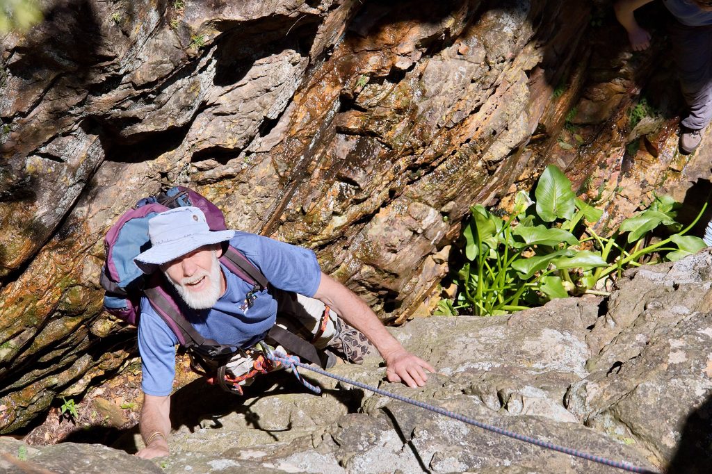 Older man rock climbing.