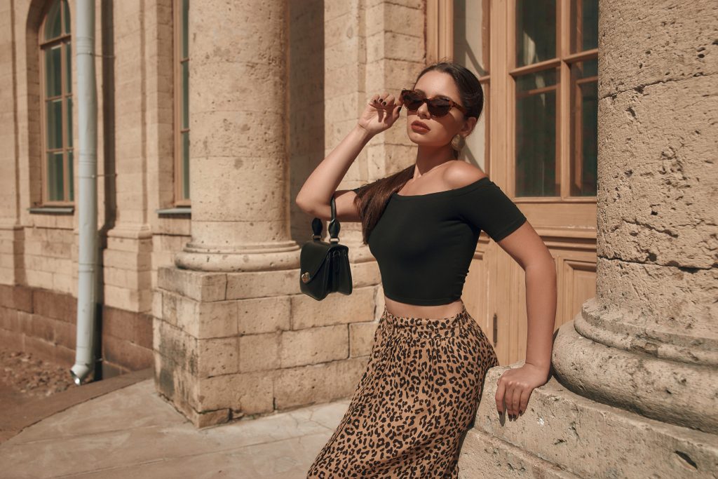 a woman wearing a leopard skirt and black shirt.