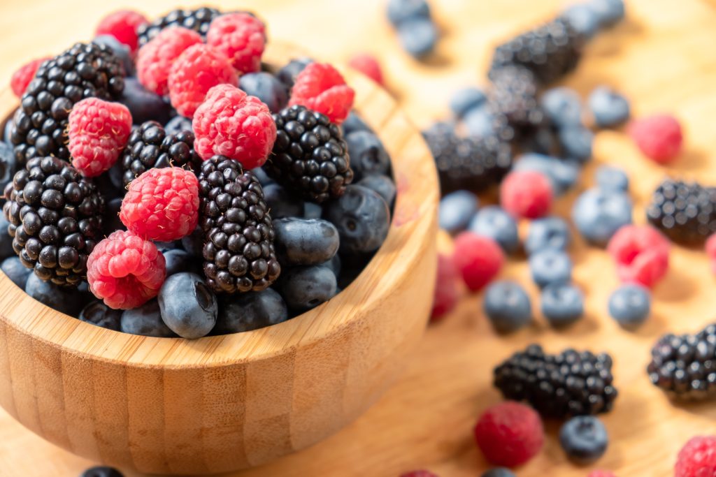 A wood bowl filled with a mix of berries.