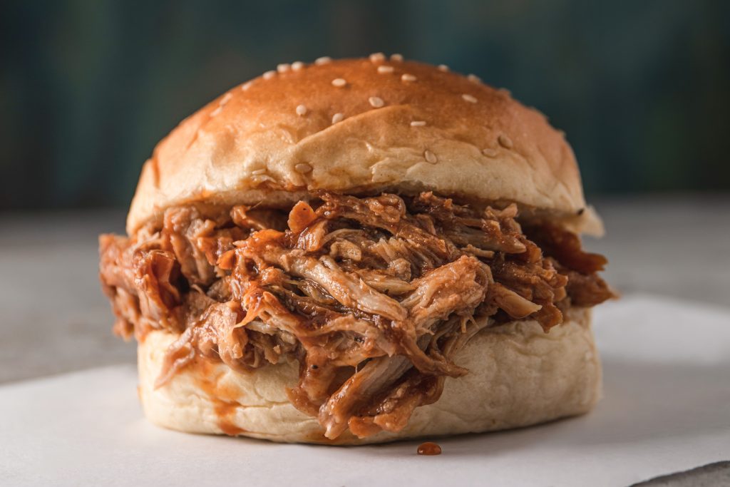 Pulled BBQ chicken on a hamburger bun.