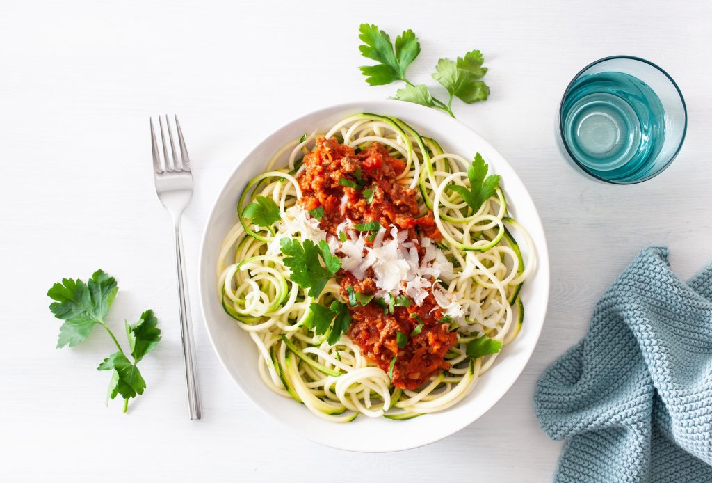 zoodles and marinara sauce on a white plate.
