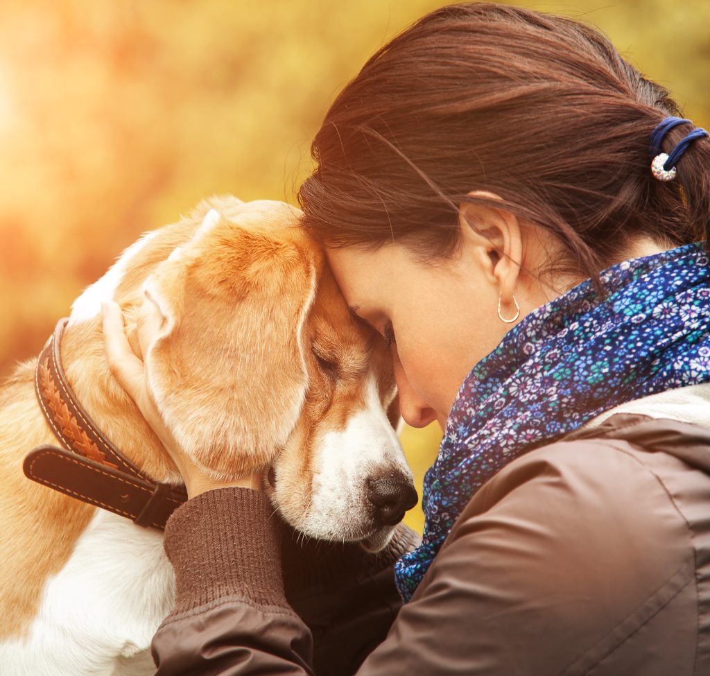 a woman hugging her dog.