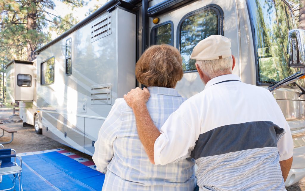 The back of an older man  and woman looking towards an RV.