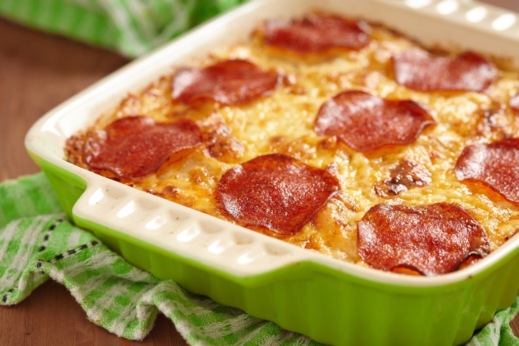 Pizza bake casserole in a green baking dish.