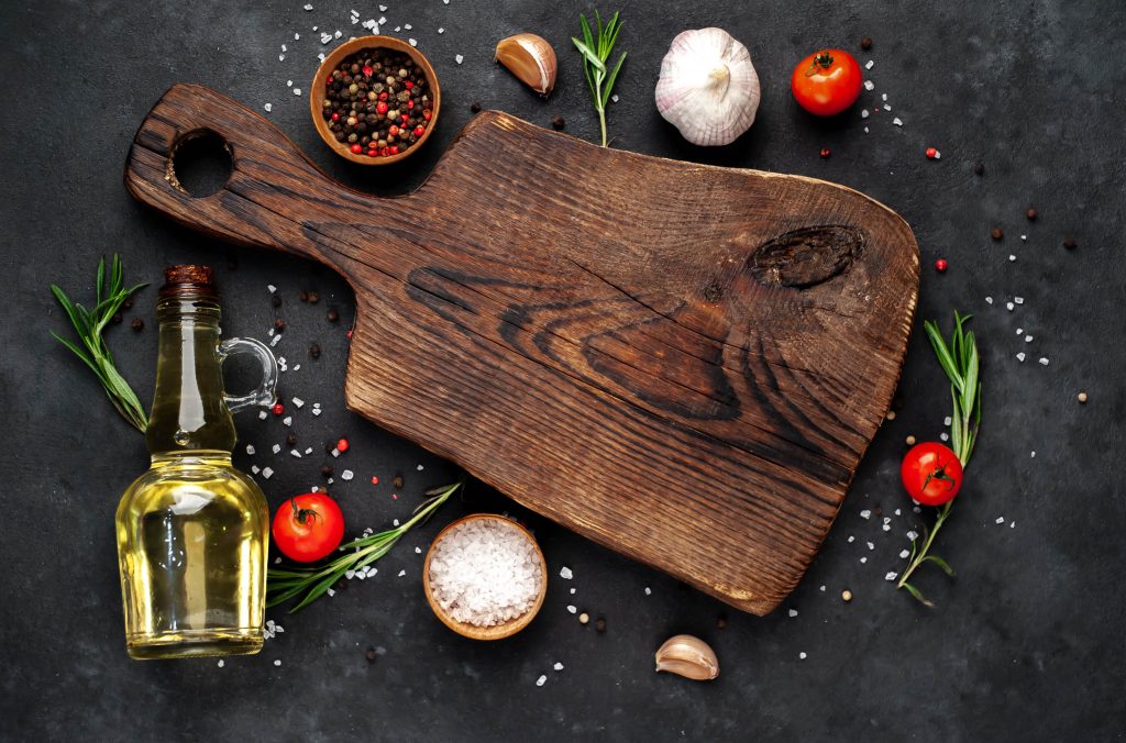 Wood cutting board and veggies, oil.