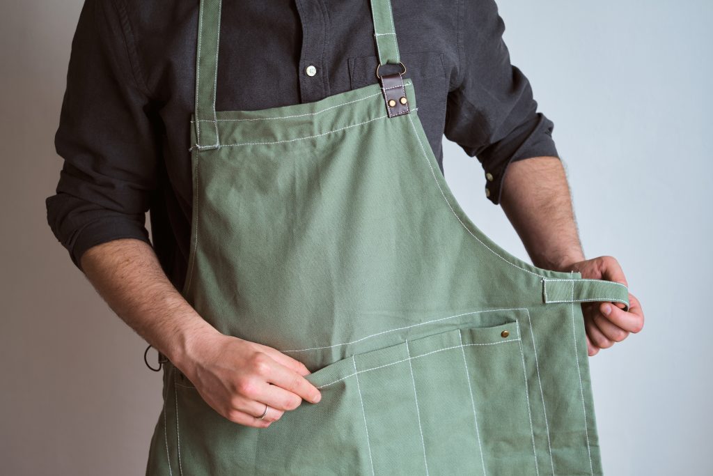 a person wearing a green apron.