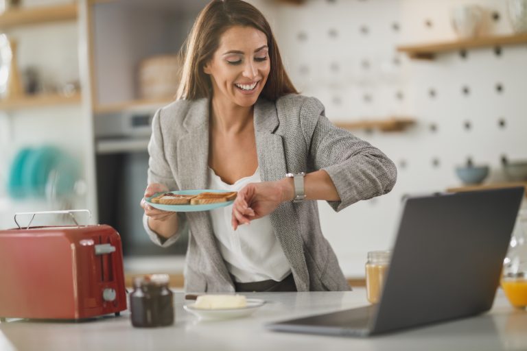 a business woman looking at her watch holding a plate of toast.