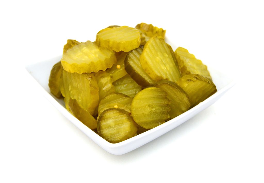 a white bowl of pickles.