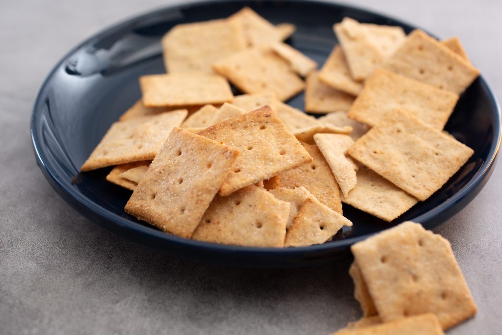 a black bowl filled with almond flour crackers.