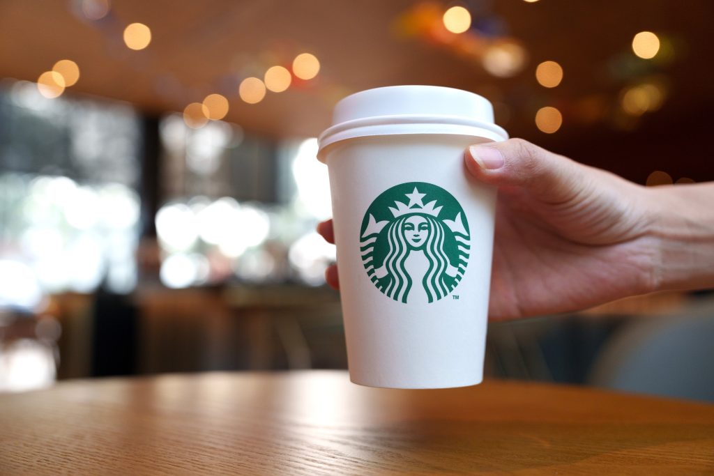 A hand holding a Starbucks cup.