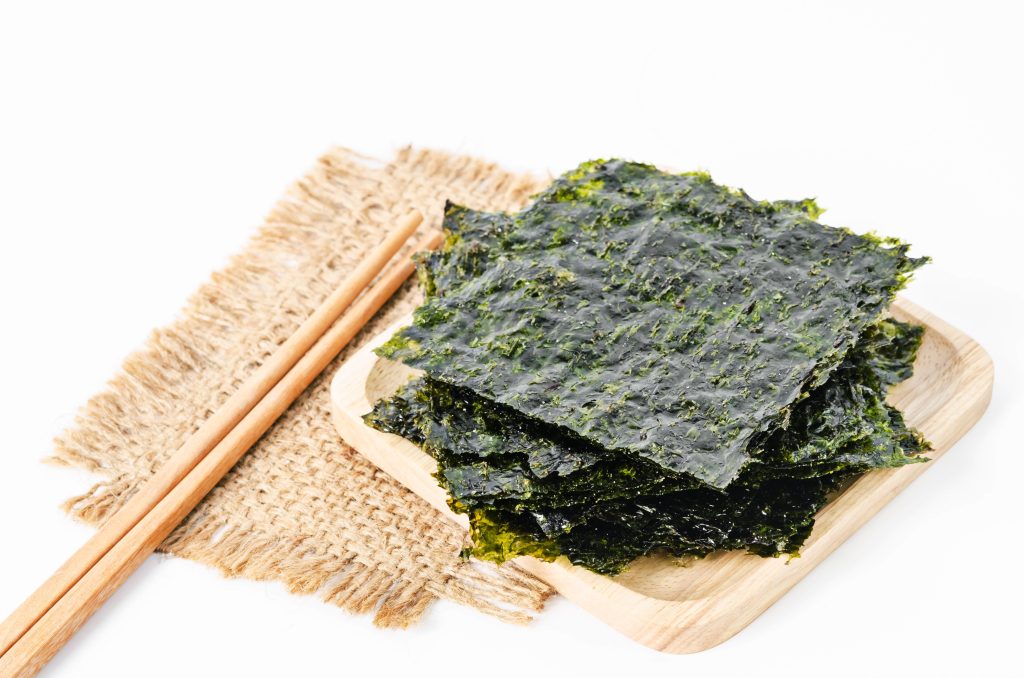 a stack of seaweed sheets and a set of wooden chopsticks.