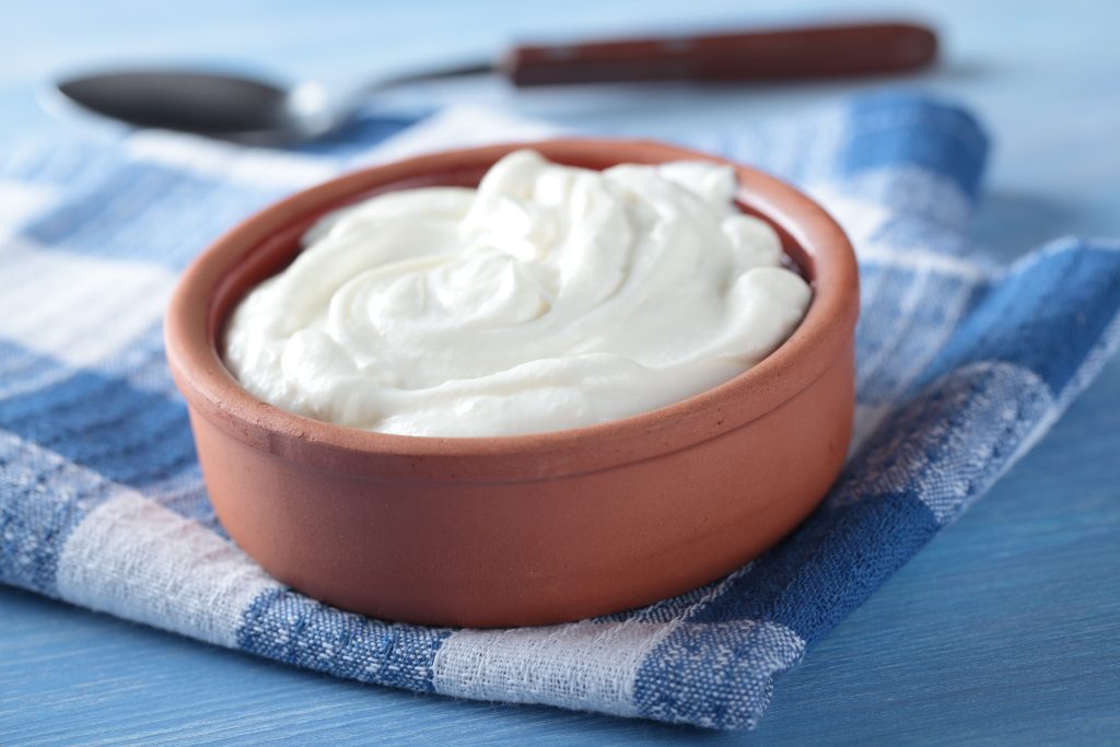 A wooden bowl filled with Greek yogurt.