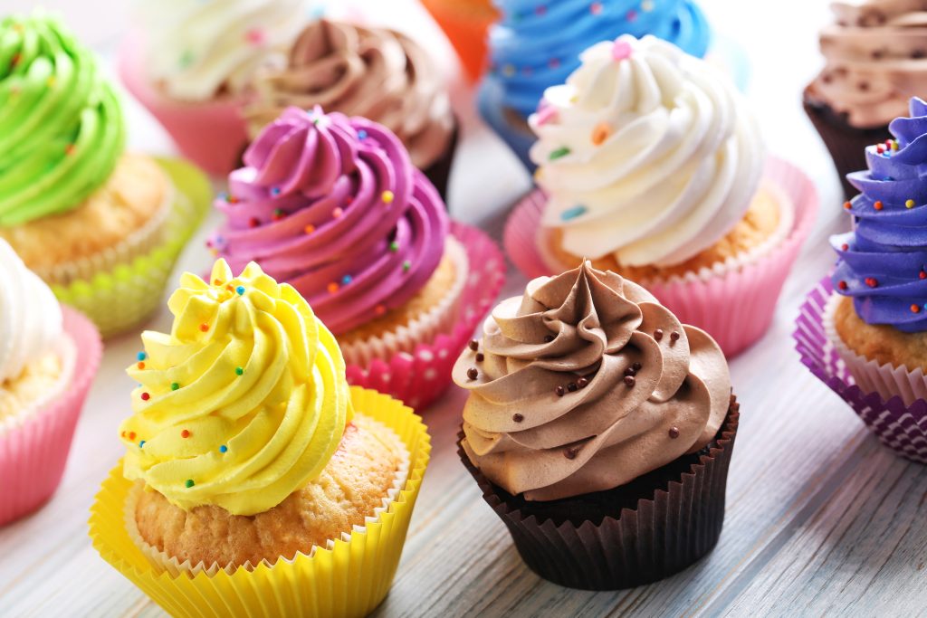 a colorful variety of cupcakes with frosting.