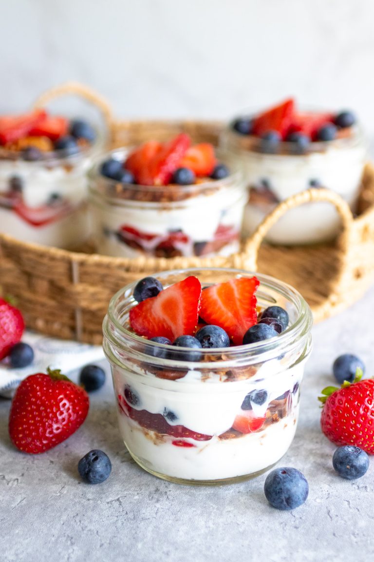 yogurt berry granola parfaits in glass jars.